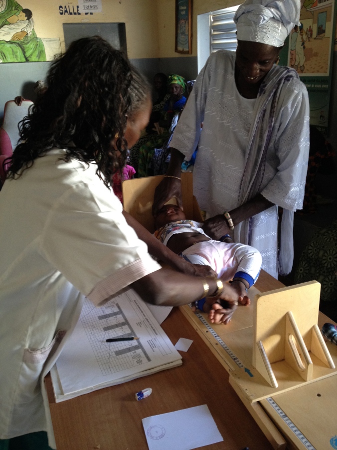 Khathya, a nurse assistant, measuring a child as part of the malnutrition screening program