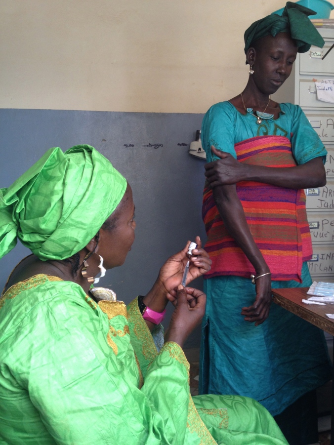 My host mom Fatou, a traditional midwife, giving a woman a birth control shot 